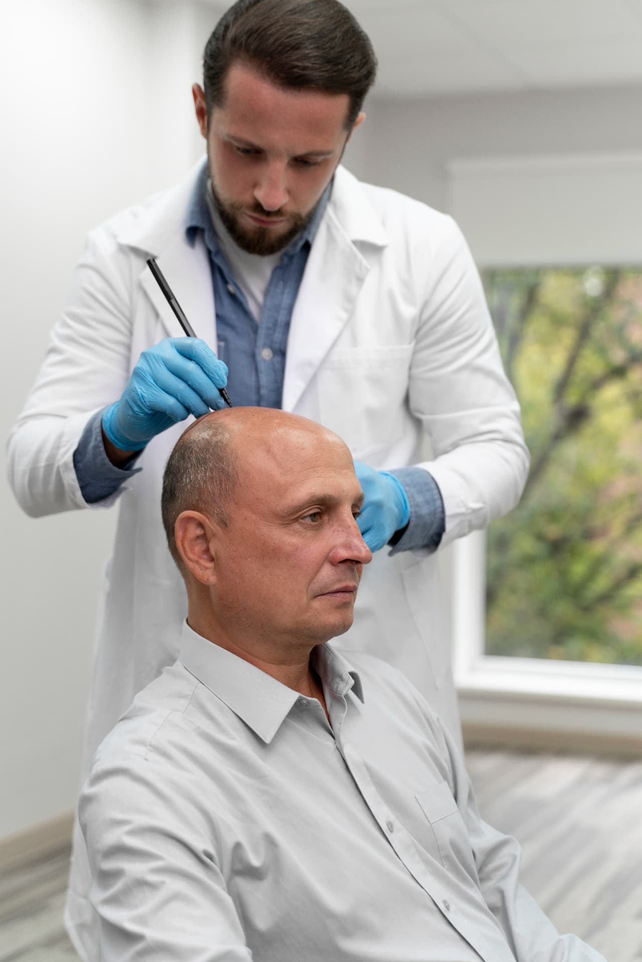 Clinician marking a patient's scalp during a hair restoration treatment